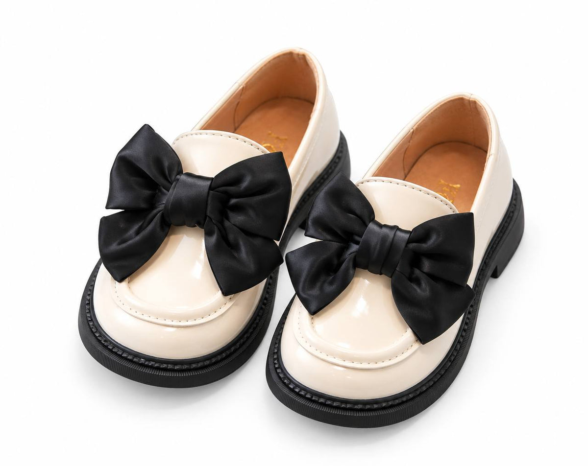 Beige patent loafers with black satin bows